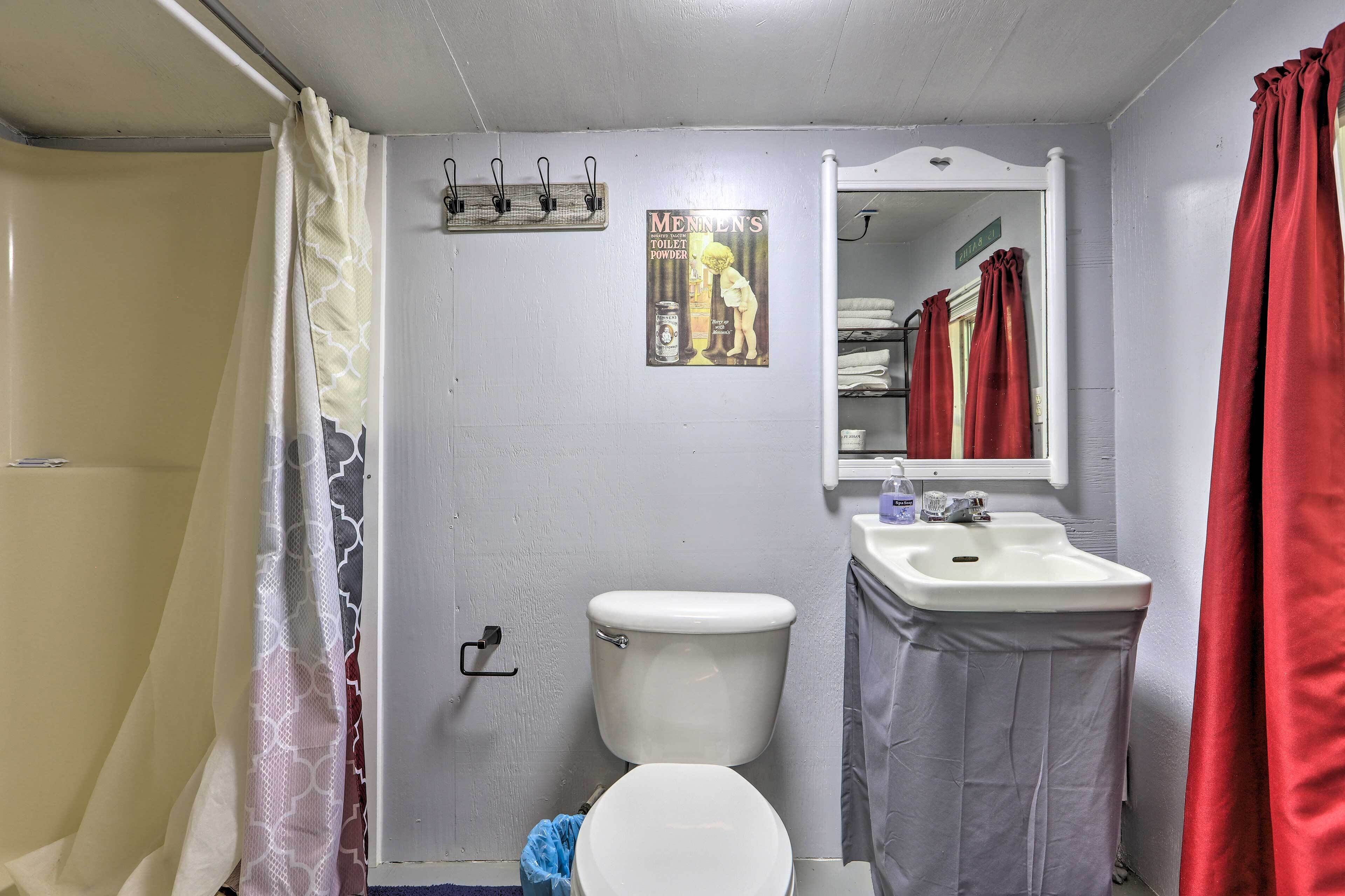 Une salle de bain équipée de toilettes, d’un lavabo et d’un rideau de douche.