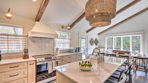 A spacious kitchen with a large island, modern appliances, and a chandelier. - The Ultimate Luxury Retreat on Lake Burton! (Clayton)