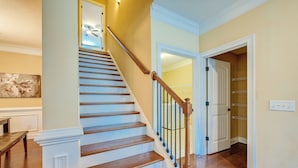 A staircase with wooden steps and a white handrail, leading to a room with a door and a light switch on the wall. - Spacious Kathleen Vacation Rental w/ Fireplace (Kathleen)
