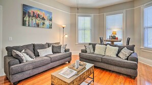A living room with two grey sofas, a wooden coffee table, and a painting of a cityscape. - Airy Vacation Rental in Augusta, Georgia! (Augusta)