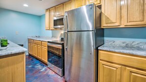 A kitchen with wooden cabinets, a stainless steel refrigerator, a microwave, and a built-in oven. - Decatur Apartment w/ Tennis Court ~ 11 Mi to ATL (Decatur)