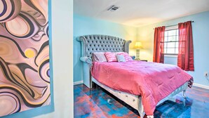A bedroom with a tufted headboard, a pink bedspread, and a blue and red floor. - Decatur Apartment w/ Tennis Court ~ 11 Mi to ATL (Decatur)