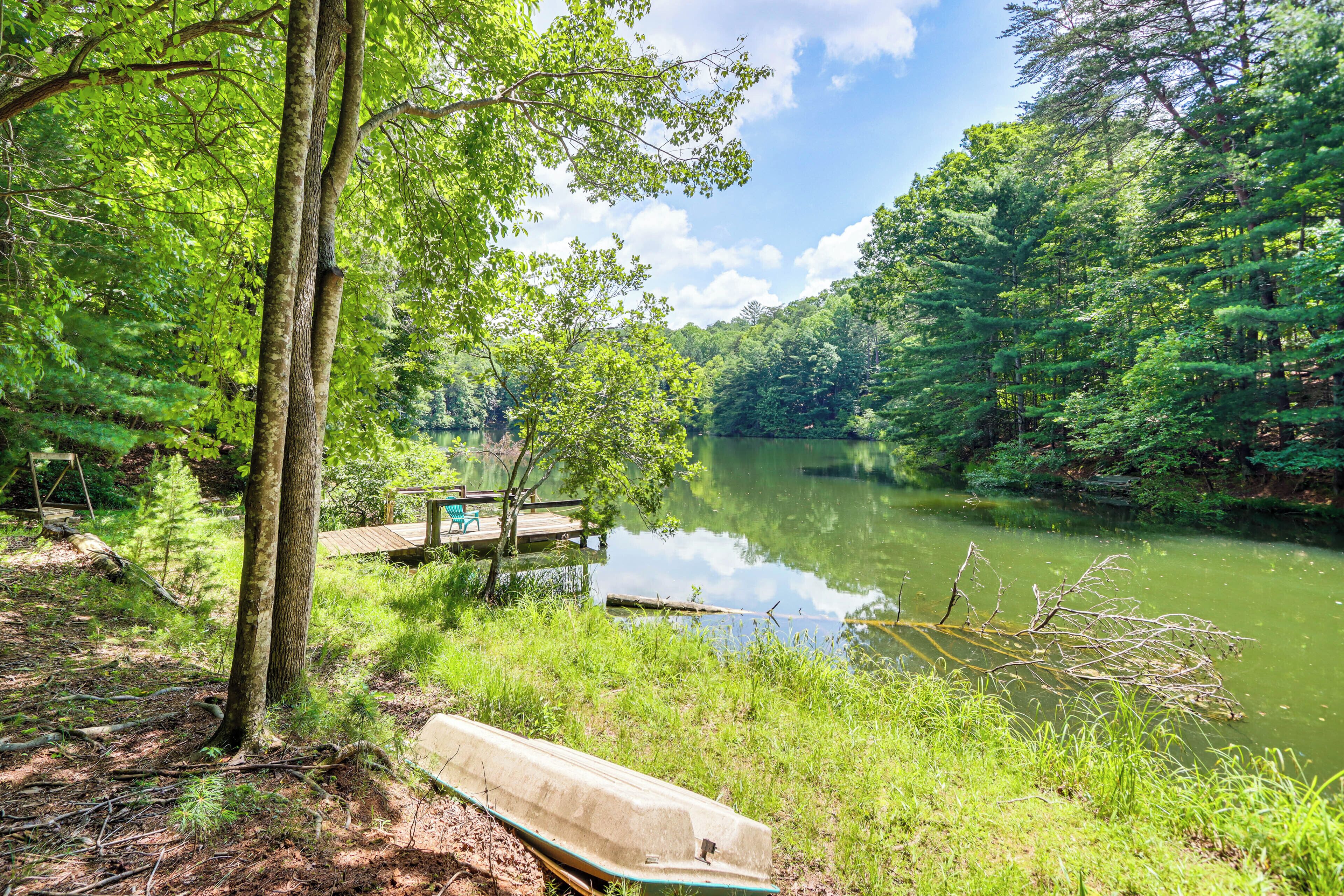A serene lakeside setting with a wooden dock and a canoe.