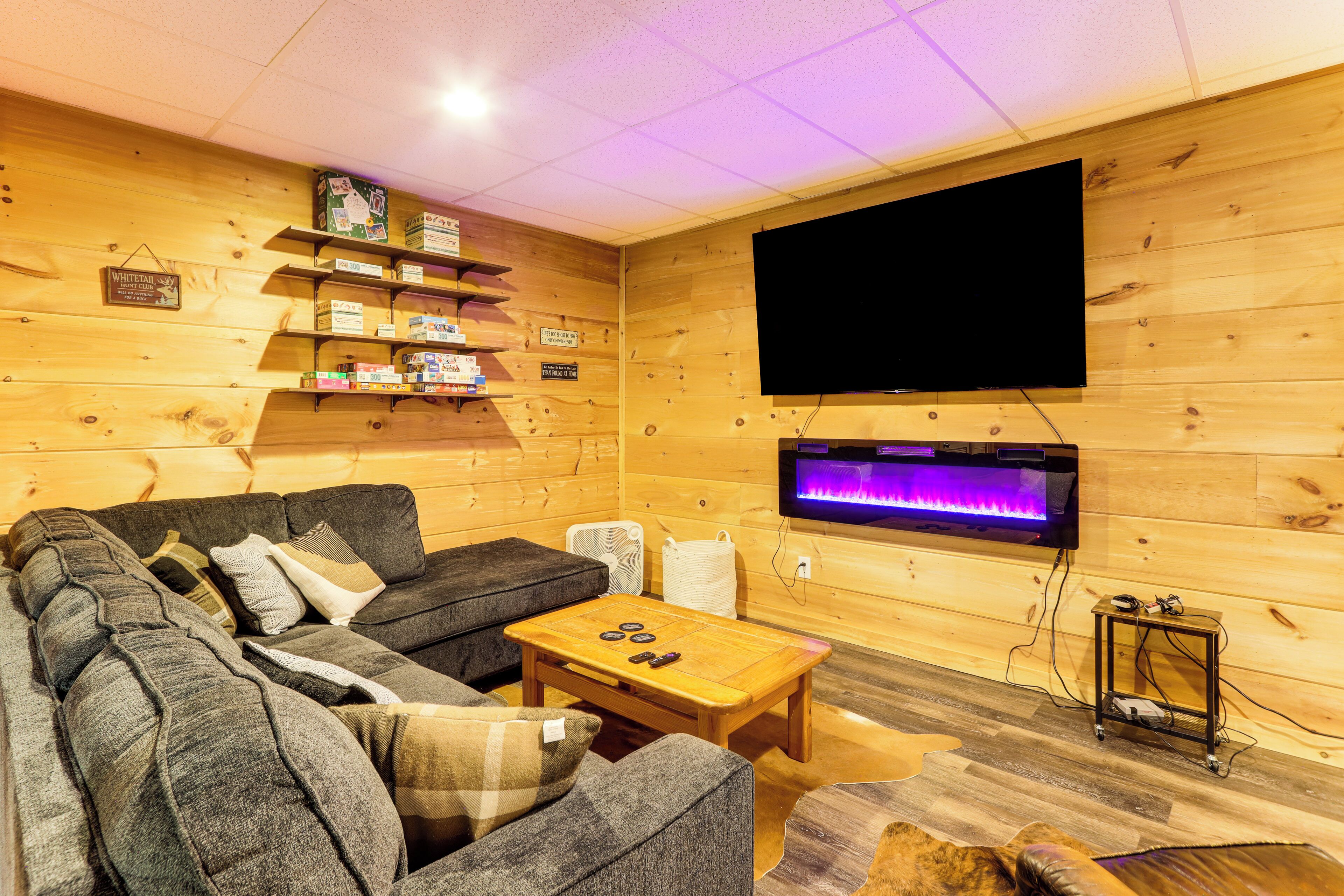 Een gezellige woonkamer met een modulaire bank, een houten salontafel en een flatscreen televisie aan de wand.