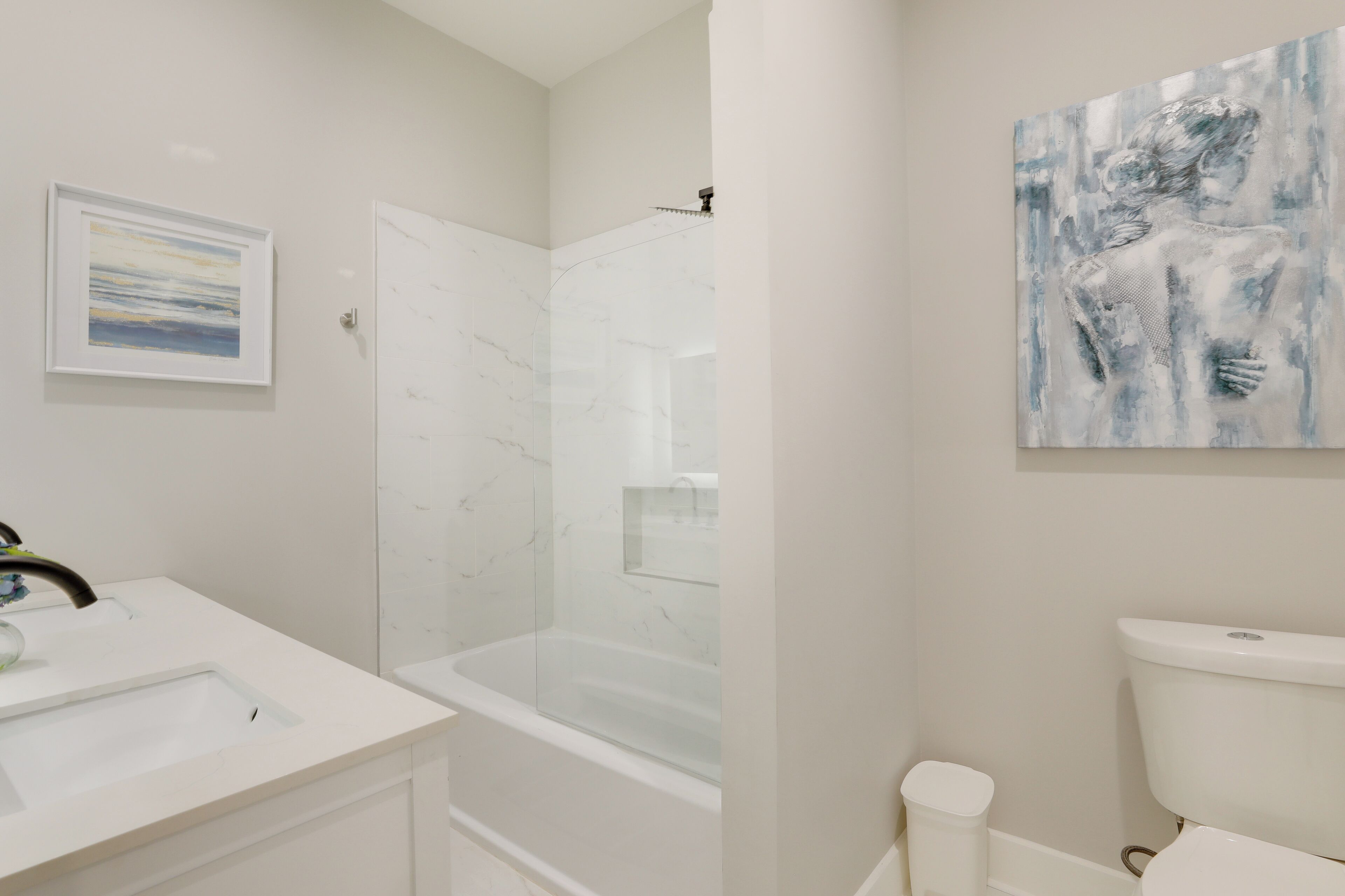 Un baño moderno con ducha de mármol, inodoro y lavamanos.
