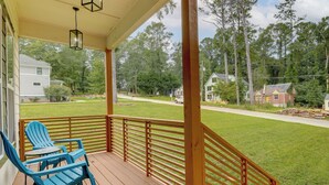 A wooden porch with a railing, a blue Adirondack chair, and a table. - Modern Decatur Home ~ 7 Mi to Atlanta! (Decatur)