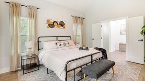 A bedroom with a bed, bedside tables, a bench, and a wall art piece. - Modern Decatur Home ~ 7 Mi to Atlanta! (Decatur)