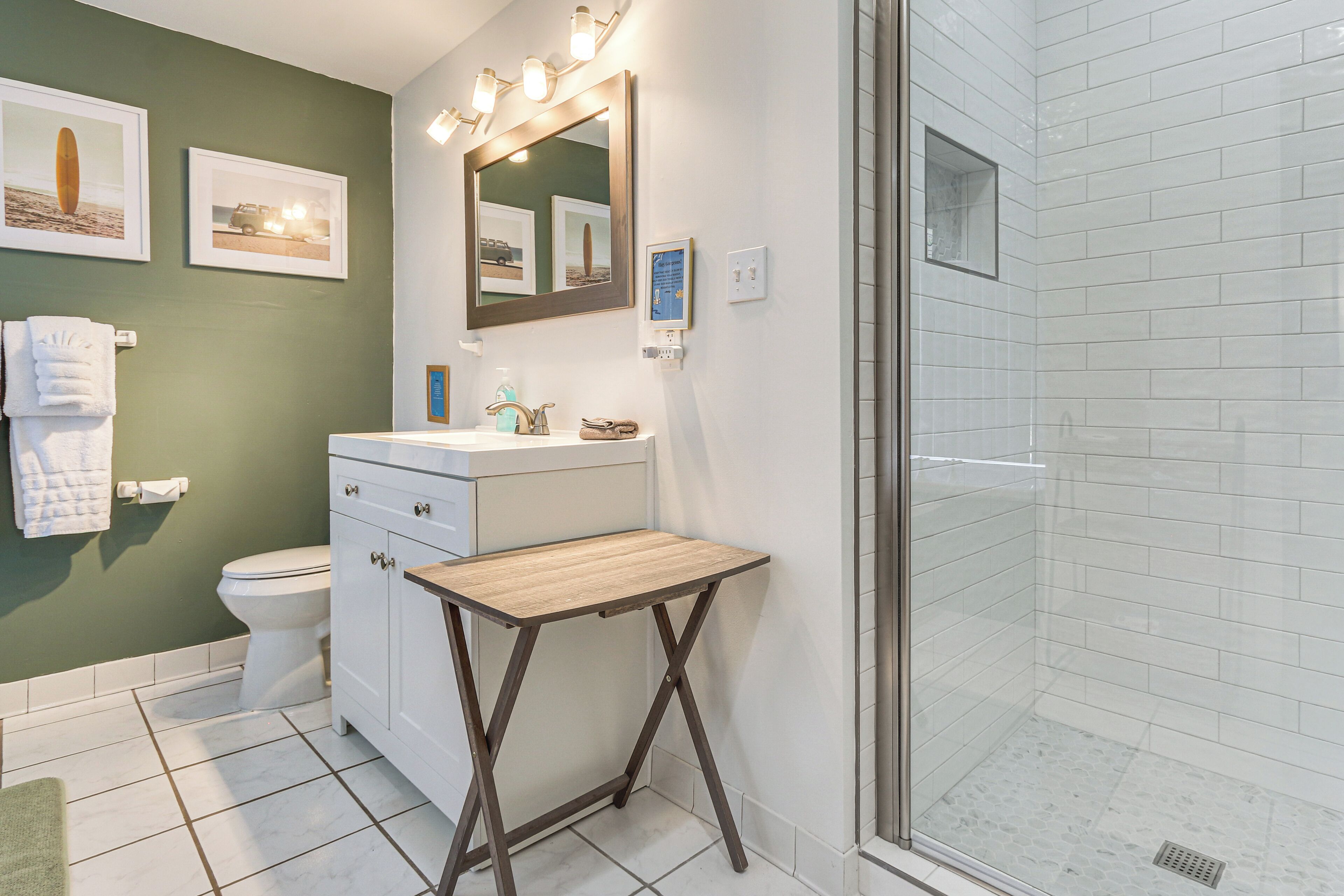 Une salle de bain comprenant des toilettes, un lavabo, un meuble-lavabo et un espace douche.
