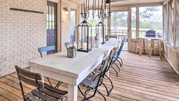 A covered patio with a long dining table, chairs, and a grill area. - Charming Retreat on 80-acre Willow Rock Ranch! (Woodbury)