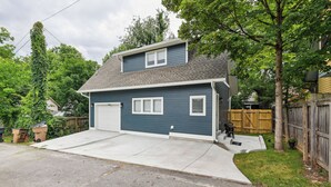 A two-story house with a garage, a front yard, and a wooden fence. - Nashville Vacation Rental Near Bridgestone Arena! (Nashville)