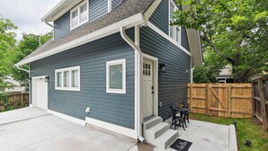 A two-story house with a front porch, a garage, and a wooden fence. - Nashville Vacation Rental Near Bridgestone Arena! (Nashville)
