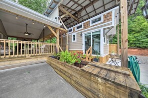 A covered outdoor area with a wooden deck, a ceiling fan, and potted plants. - Blairsville Tiny Home w/ Covered Furnished Deck! (Blairsville)