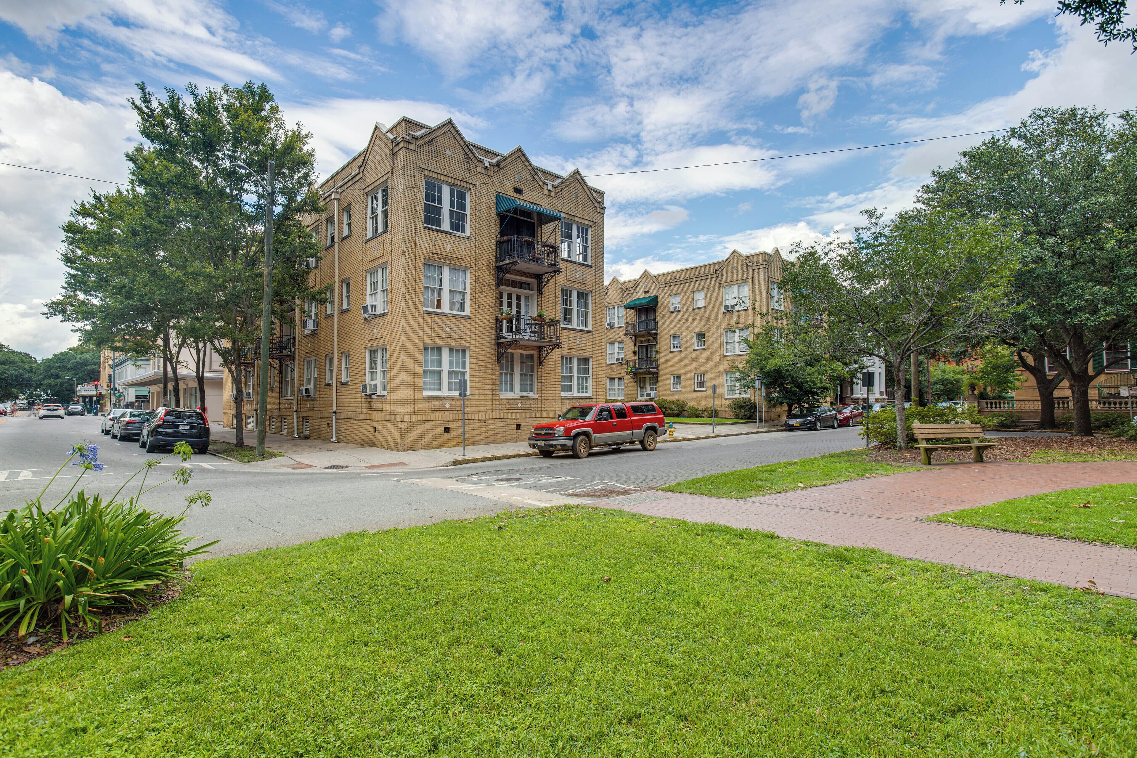 A multi-story residential building with a brick facade, multiple windows, and balconies.