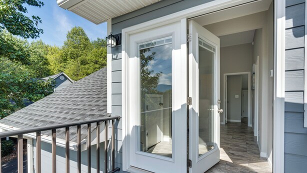 A residential building with a sliding glass door entrance, a covered porch, and a visible interior hallway. - Young Harris Vacation Rental w/ Mountain Views! (Young Harris)