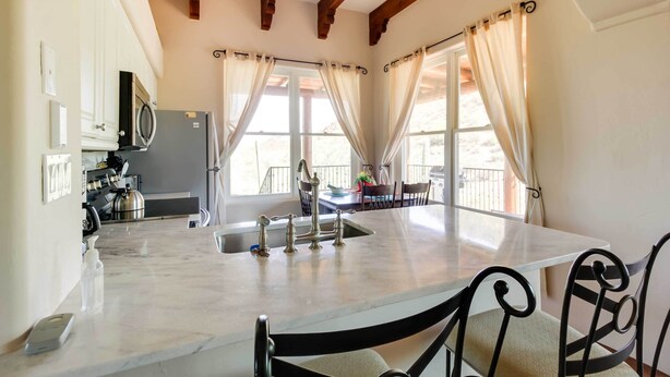 A kitchen with a marble countertop, stainless steel appliances, and a ceiling fan. - Mountain Views & Private Jacuzzi: Tucson Casita (Tucson)