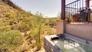 A hot tub area with a view of a desert landscape, including cacti and sparse vegetation. - Mountain Views & Private Jacuzzi: Tucson Casita (Tucson)