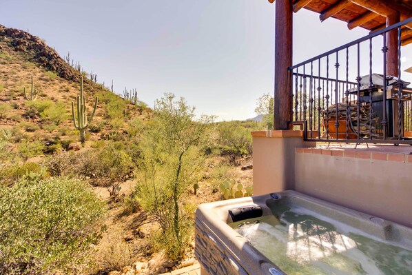 A hot tub area with a view of a desert landscape, including cacti and sparse vegetation. - Mountain Views & Private Jacuzzi: Tucson Casita (Tucson)