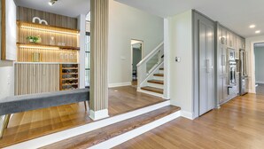 Una cocina moderna con armarios grises, electrodomésticos de acero inoxidable y suelo de madera.