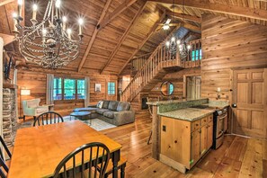 A spacious log cabin with a large dining area, a cozy living room with a sectional sofa, a kitchen with granite countertops, and a wooden staircase. - Big Canoe Mountain Resort Cabin w/ Pool Access! (Jasper)