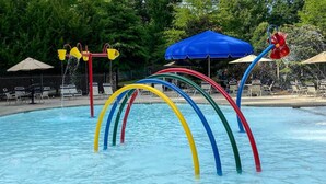 Une piscine avec des toboggans colorés et des parasols.