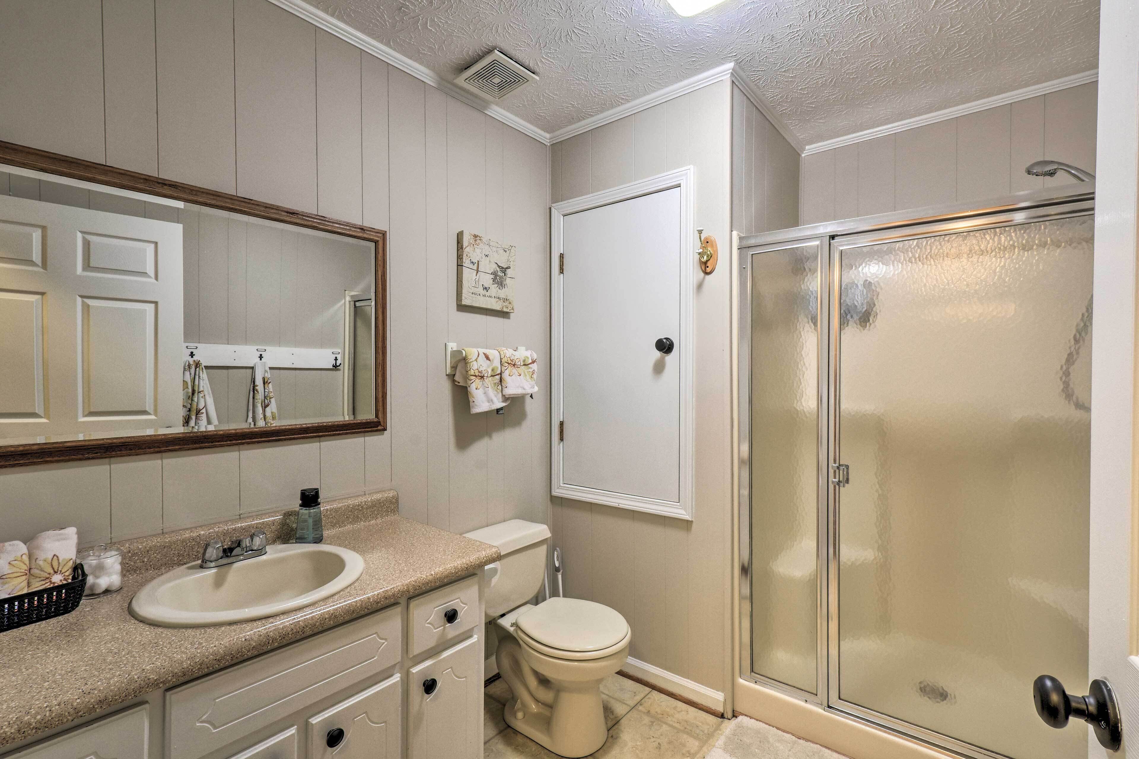A bathroom with a sink, toilet, and glass shower enclosure.