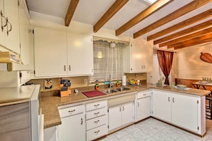 A kitchen with white cabinets, a granite countertop, and wooden beams on the ceiling. - Renovated Tucson Gomez Casita w/ Yard < 7 Mi to DT (Tucson)