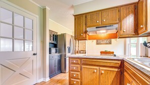 A kitchen with wooden cabinets, a refrigerator, and a microwave. - Decatur Vacation Rental w/ Patio! (Decatur)
