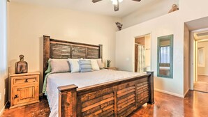 A bedroom with a wooden bed, a nightstand, a mirror, and a ceiling fan. - Fenced Yard & Grill! Tucson Family Escape (Tucson)