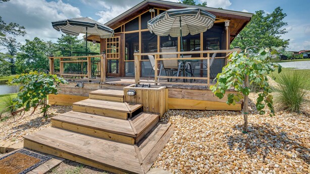 A wooden cabin with a deck, outdoor seating, and a view of the surrounding landscape. - Spacious Buena Vista Cabin w/ Lake Views & Deck (Buena Vista)