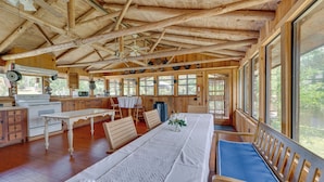 A rustic wooden cabin with a dining area, kitchen, and large windows. - Spacious Buena Vista Cabin w/ Lake Views & Deck (Buena Vista)