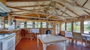 A rustic kitchen with wooden beams, a large window, and a dining area with a table and chairs. - Spacious Buena Vista Cabin w/ Lake Views & Deck (Buena Vista)