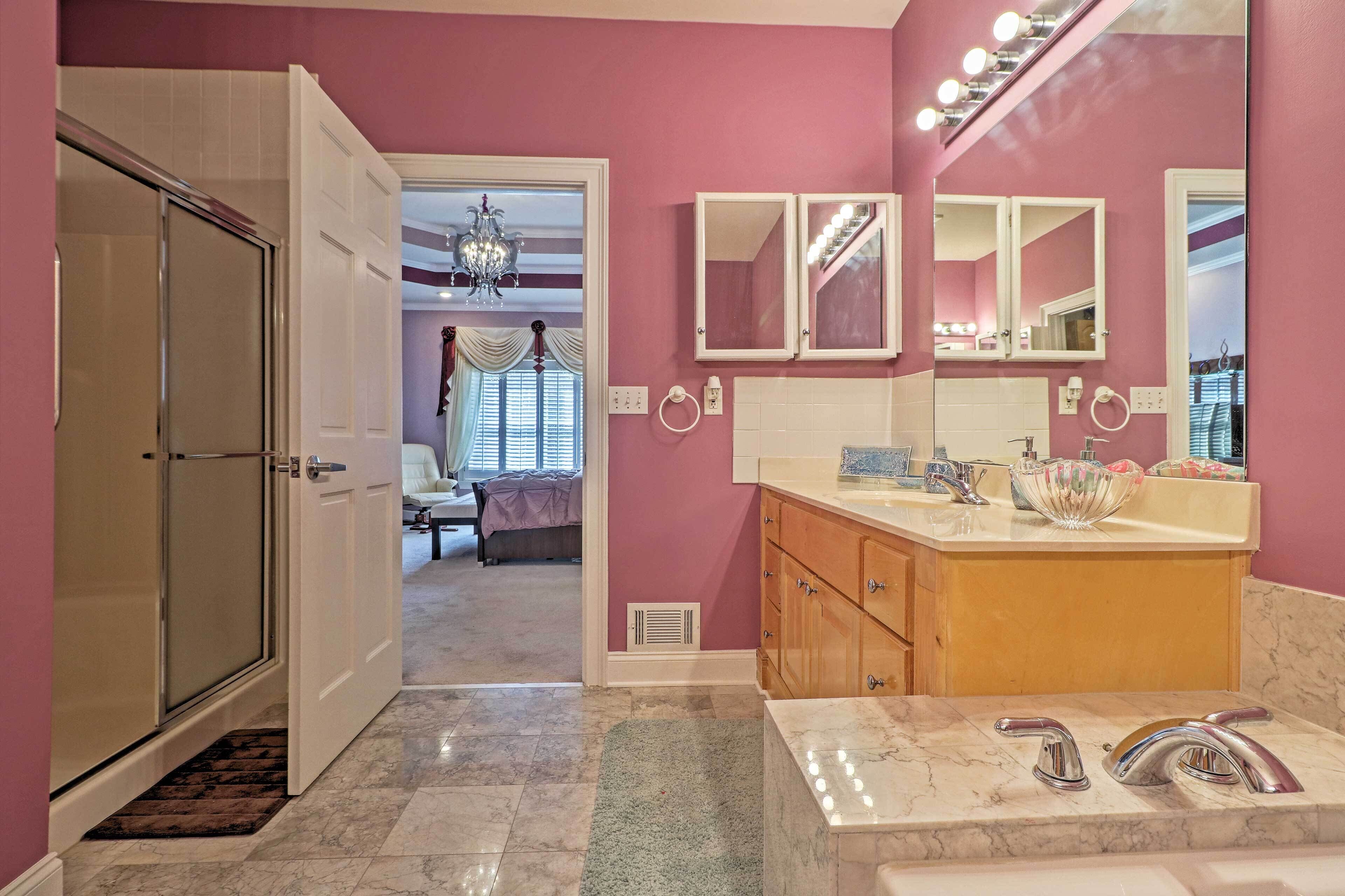 A bathroom with a vanity, a large mirror, and a shower area.