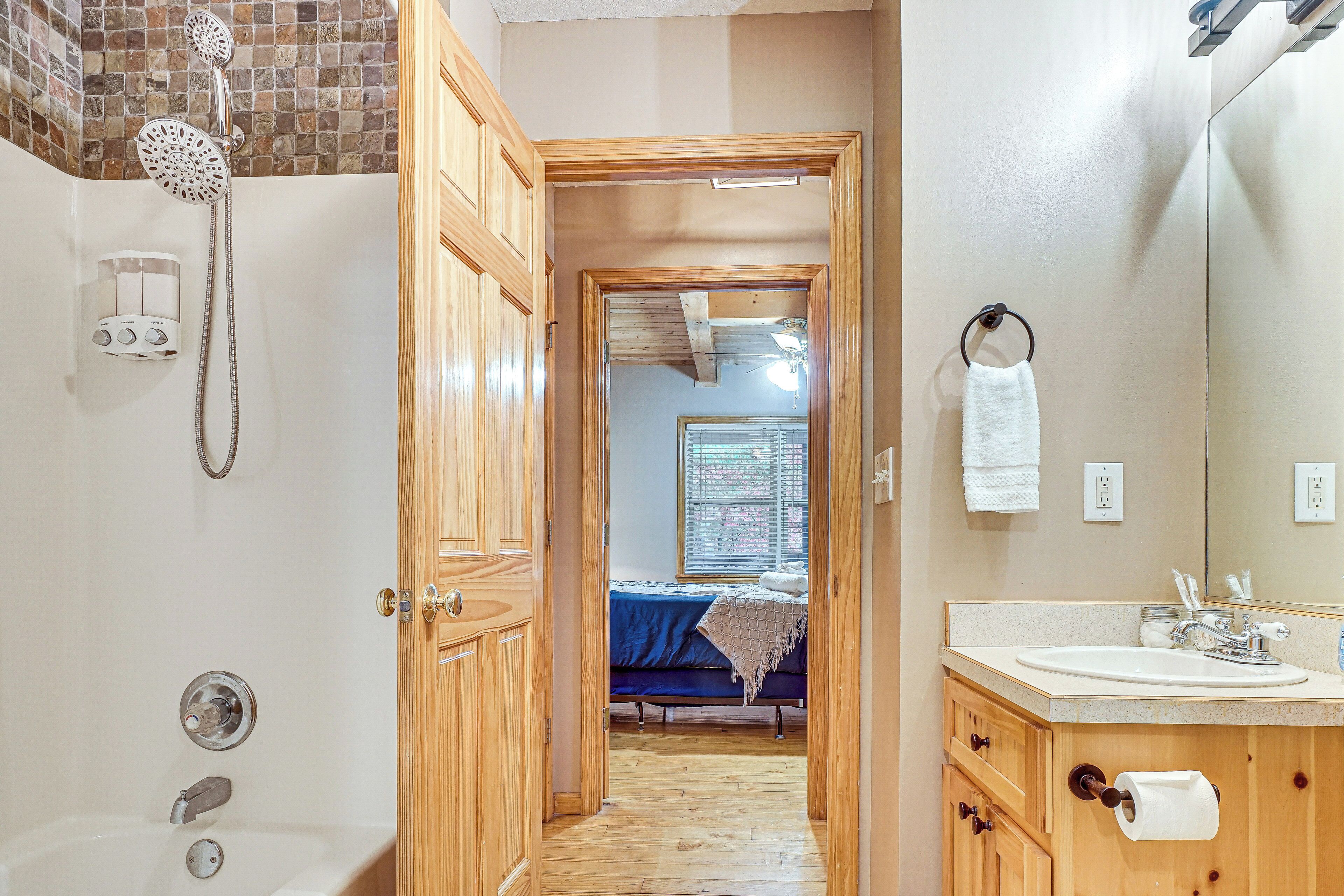 A bathroom with a shower, a sink, and a mirror.