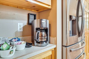 A kitchen with a coffee maker, a refrigerator, and a coffee pod holder. - Spacious Home in Helen w/ Porch & Balcony! (Helen)