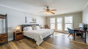 A bedroom with a bed, a desk, a chair, a ceiling fan, and a window. - Lake Sinclair Retreat w/ Big Water Views & Dock! (Milledgeville)