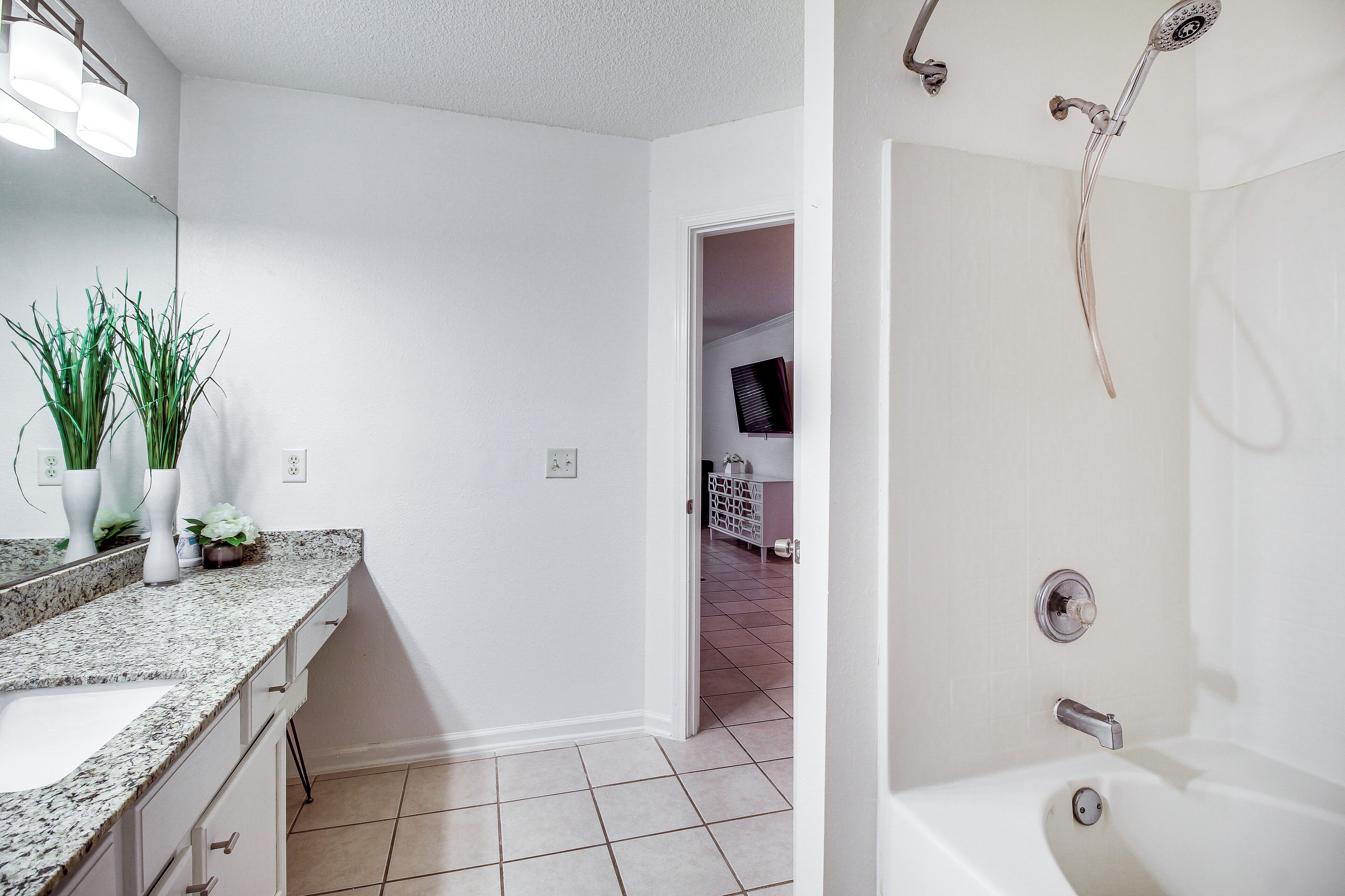 A bathroom with a shower, a sink, and a mirror.