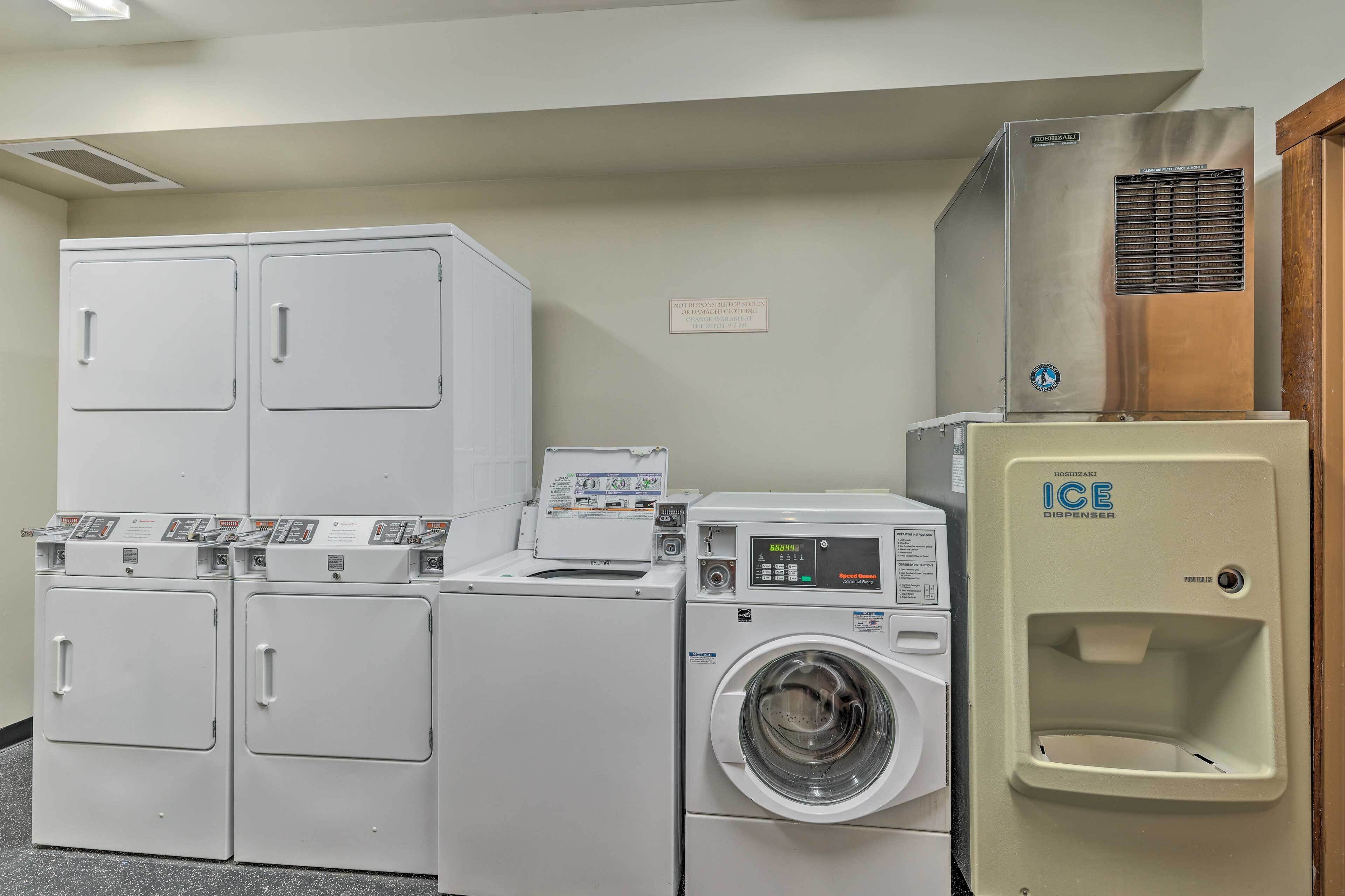 A laundry facility with stacked dryers, a front-loading washing machine, and an ice dispenser.