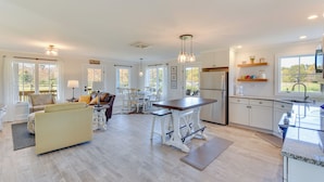 A spacious kitchen with a dining area, large windows, and a view of the outdoors. - Modern Clarkesville Cottage w/ Decks & Patio! (Clarkesville)