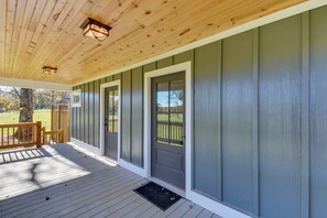 A covered porch with a wooden ceiling and a view of a grassy yard. - Modern Clarkesville Cottage w/ Decks & Patio! (Clarkesville)