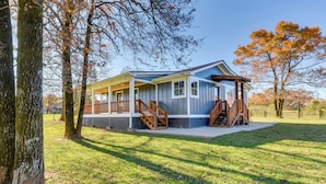 A two-story house with a porch and a covered staircase. - Modern Clarkesville Cottage w/ Decks & Patio! (Clarkesville)