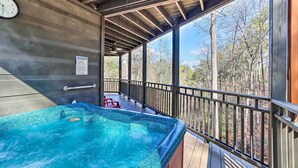 A hot tub on a wooden deck with a view of trees. - Spacious Ellijay Resort Home w/ Hot Tub! (Ellijay)