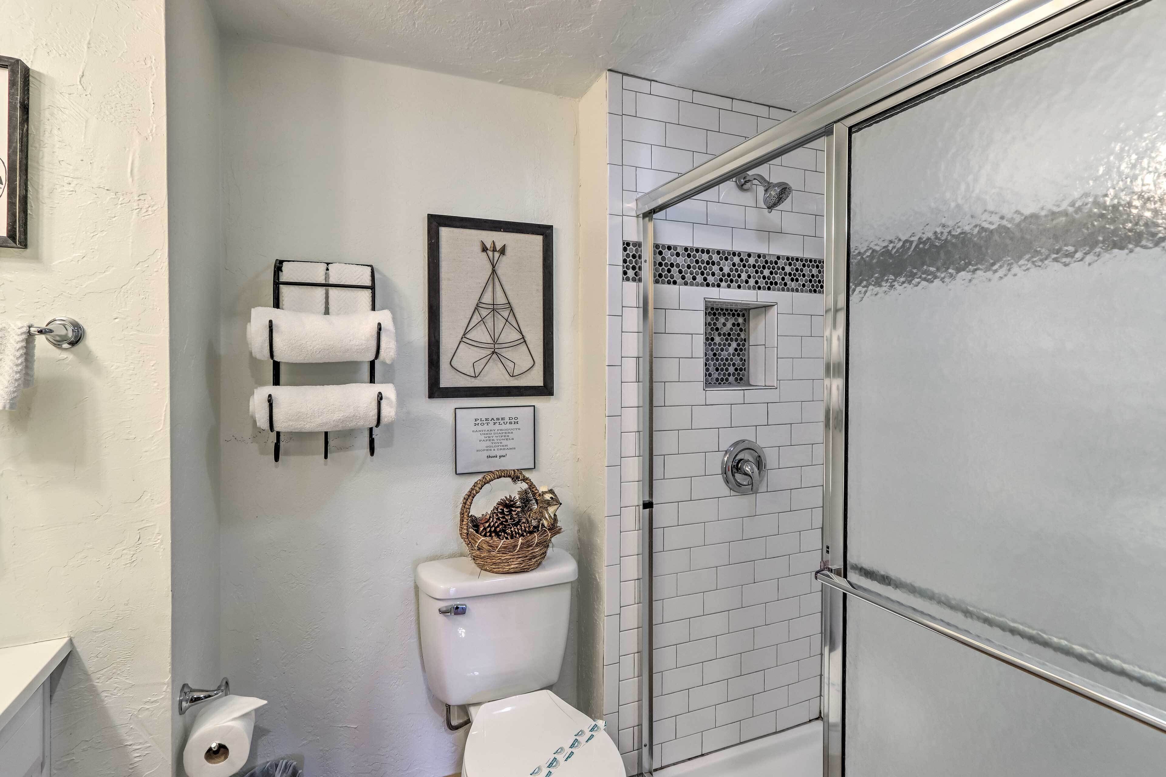 A bathroom with a toilet, a shower, and a towel rack.