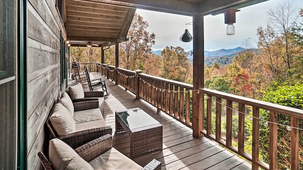 A wooden deck with wicker furniture and a view of autumn foliage and mountains. - Hiawassee Cabin w/ Mtn Views < 1 Mi to Lake! (Hiawassee)