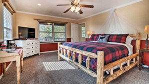 A bedroom with a wooden bed frame, a ceiling fan, a television, and a window with blinds. - Hiawassee Cabin w/ Mtn Views < 1 Mi to Lake! (Hiawassee)