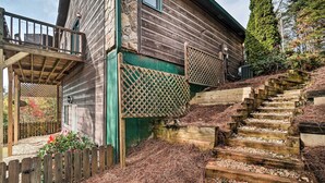 A rustic wooden cabin with a wooden deck and a stone wall. - Hiawassee Cabin w/ Mtn Views < 1 Mi to Lake! (Hiawassee)