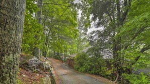 A forested area with a paved path leading to a wooden structure. - Mountain Resort Home w/ Views, By Sky Valley Golf! (Dillard)