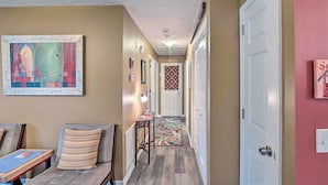 A hallway with a patterned rug, a framed artwork on the wall, and a door with a decorative panel. - Lively East Nashville Pad: Walk to Bars & Eateries (Nashville)