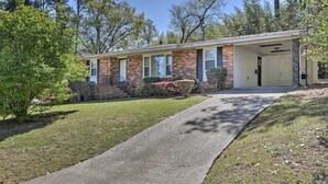 A single-story brick house with a covered porch, a front door, and a small front yard with a pathway leading to the entrance. - Spacious Retreat ~ 1 Mile to Augusta National! (Augusta)