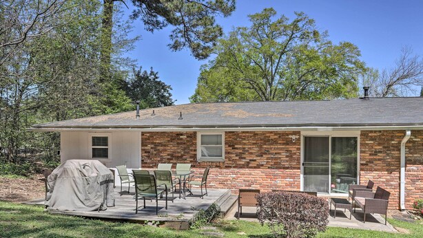 A single-story brick house with a covered patio, outdoor furniture, and a small garden. - Spacious Retreat ~ 1 Mile to Augusta National! (Augusta)