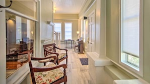 A hallway with wooden chairs, a piano, and a fireplace. - Pet-friendly Natchez Home: Walk to Downtown! (Natchez)
